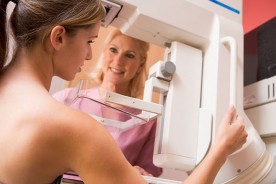 a nurse assisting a patient with a mammogram test